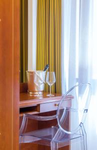 a glass chair sitting on a desk with two glasses at Hotel Adriatico in Venice