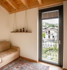 salon z kanapą i dużym oknem w obiekcie foresteria stazzona w mieście Villa di Tirano