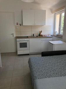 uma cozinha com armários brancos e um forno com placa de fogão em RougeMARIN apartments em Senj