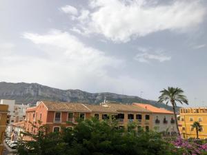 a city with buildings and palm trees and mountains at Diana 16 in Denia
