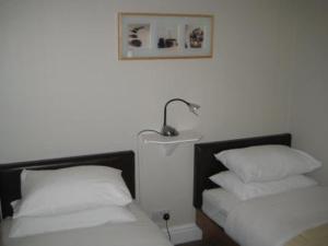 ein Schlafzimmer mit 2 Betten und einer Lampe an der Wand in der Unterkunft The Kings Arms in Wilmslow