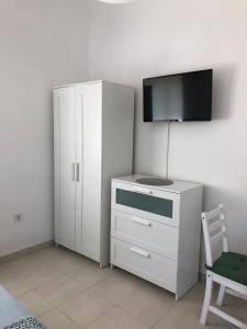 ein weißer Schrank mit einem Fernseher darüber in der Unterkunft RougeMARIN apartments in Senj