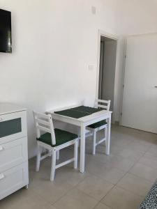 a white table and two chairs in a room at RougeMARIN apartments in Senj