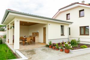 a white house with a patio and a table at SoleGutta in Kolárovo