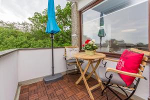 a patio with a table and two chairs and an umbrella at Ferienwohnung Beachhus in Scharbeutz