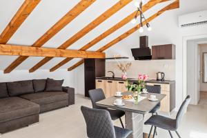 un salon avec une table, des chaises et un canapé dans l'établissement Apartmani Bruna, à Šibenik