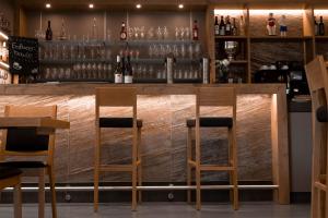 um bar num restaurante com dois bancos de madeira em Ludgerusbrunnen Hotel Mertens em Billerbeck