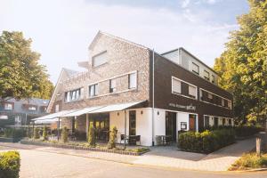 um grande edifício de tijolos com uma frente de loja em Ludgerusbrunnen Hotel Mertens em Billerbeck