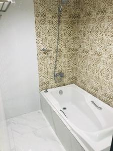 ein Badezimmer mit einer weißen Badewanne und einer Dusche in der Unterkunft Urban Travellers Hotel in Manila