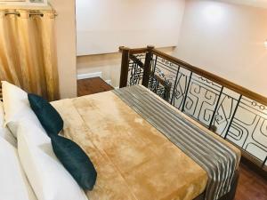 um quarto com uma cama e uma cabeceira em madeira em Urban Travellers Hotel em Manilla