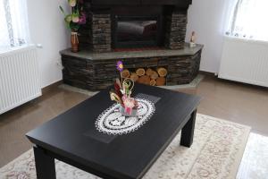 een zwarte tafel in een woonkamer met een open haard bij Pensiunea Diana in Moisei