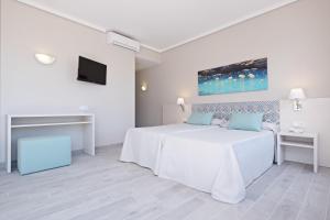 a white bedroom with a bed and a tv at azuLine Hotel Llevant in San Antonio