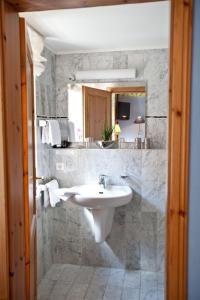 a white bathroom with a sink and a mirror at Hotel Altes Stadthaus in Westerstede