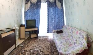 a room with a bed and a tv and a window at Apartment 6 Mikrorayon in Kurgan