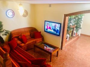 a living room with a couch and a flat screen tv at GRAN CASA con TERRAZA a 3 min Playa con Wifi - rodeada de servicios in Roquetas de Mar