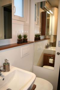 a bathroom with a sink and a toilet and a mirror at Floating House Marina Royal in Portorož