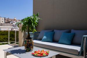 a couch on a balcony with a bowl of fruit on a table at Charme SIMON BOLIVAR in Noto