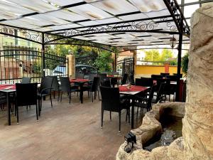 クラネヴォにあるHotel Jaky SPA Complexのテーブルと椅子、暖炉のあるレストラン