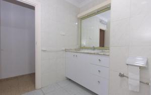 Baño blanco con lavabo y espejo en APARTAMENTO VISTABELLA, en Murcia