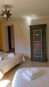 a room with two beds and a green cabinet at Chambres touristiques La Cour Des Hôtes in Obernai