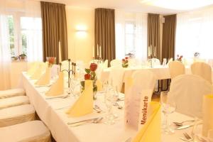 a dining room with white tables and white chairs at Hotel Altes Stadthaus in Westerstede