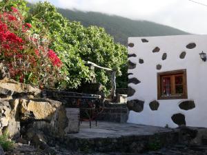 a white building with a window and some flowers at Casa Rural Los Llanillos in Frontera