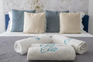 un letto con un mucchio di asciugamani arrotolati di Dimora Chlóe B&B a Pescara