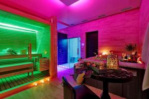 Cette chambre est dotée d'un éclairage rose et vert ainsi que d'une baignoire. dans l'établissement Colonna 32, à Rome