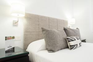 a bedroom with a white bed with two pillows at Hotel Felix in Lorca