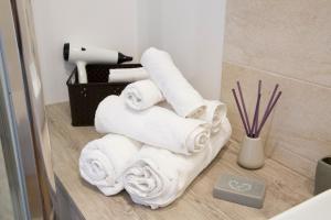 un mucchio di asciugamani su un bancone in bagno di Garibaldi Rooms a Napoli