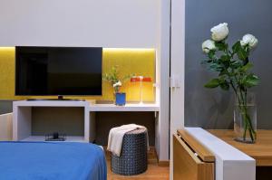 a bedroom with a tv and a vase of flowers at Colonna 32 in Rome