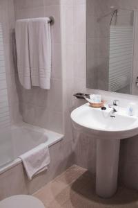 a bathroom with a sink and a toilet and a tub at Hotel Peña de Arcos in Arcos de la Frontera