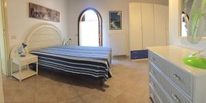 a bedroom with a bed with a blue and white striped blanket at Le Ghiaie Relax in Portoferraio