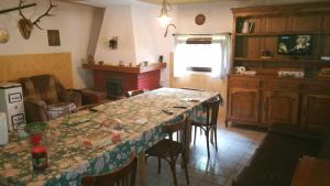 a kitchen with a long table with chairs and a tableablish at Cabana Pietricica in Dâmbovicioara