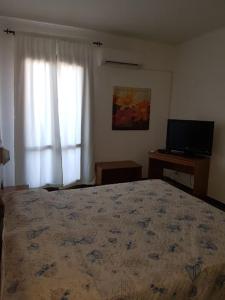 um quarto com uma cama grande e uma televisão em Villa Giada-8 appartamenti em Leporano