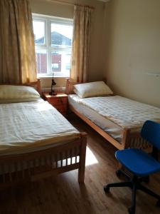 a bedroom with two beds and a chair and a window at Spacious House in Castlegar Galway in Galway