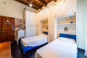 a bedroom with two beds and a desk at Le dimore sul mare in Porto Recanati