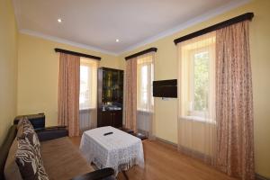 un soggiorno con un divano e due finestre di Guest House Arsan a Tsaghkadzor