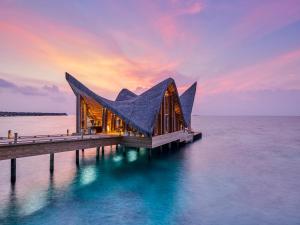 ein Gebäude auf einem Pier im Wasser in der Unterkunft JOALI Maldives in Raa Atoll