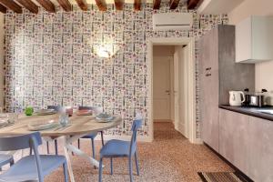 Rugabella Rialto Deluxe في البندقية: مطبخ وغرفة طعام مع طاولة وكراسي