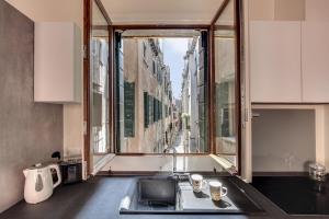 eine Küche mit einem Waschbecken und einem großen Fenster in der Unterkunft Rugabella Rialto Deluxe in Venedig