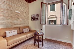 ein Wohnzimmer mit einem Sofa und einem Tisch in der Unterkunft Rugabella Rialto Deluxe in Venedig