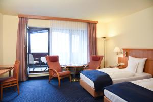 um quarto de hotel com uma cama, uma mesa e cadeiras em Parkhotel Bad Homburg em Bad Homburg vor der Höhe