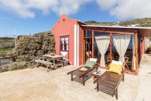 una casa en la playa con sillas y mesa en Rúbel, en Mazo