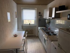 a small kitchen with a table and a window at Gemütliche Ferienwohnung mit Smart-TV in Kerpen