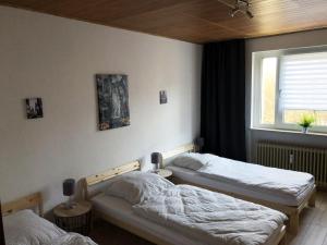 a bedroom with two beds and a window at Gemütliche Ferienwohnung mit Smart-TV in Kerpen