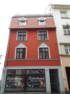 a red building with a sign in front of it at City Pension Zwickau in Zwickau
