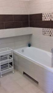 a white bath tub sitting in a bathroom at Apartament z kominkiem i wanną in Istebna