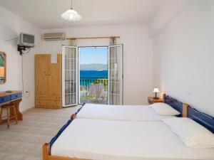 a bedroom with two beds and a view of the ocean at Dimitris Studios in Karavomylos