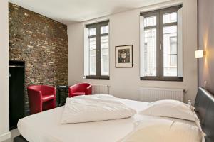 a bedroom with a bed and two red chairs at Air B&B Casa Dodo in Geraardsbergen